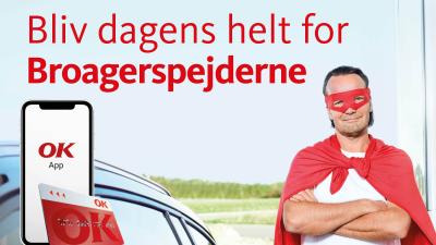 En mand står og tanker i superhelt kostume